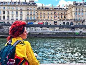 Portrait of woman standing by canal in city