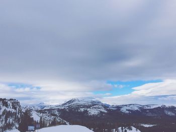 Snow covered mountains against cloudy sky