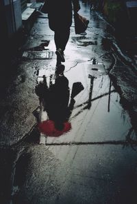 Low section of man standing on puddle