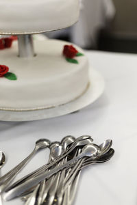 High angle view of spoons by wedding cake on table