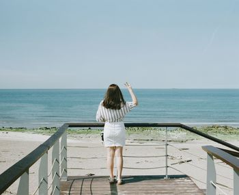 Rear view of woman looking at sea against sky