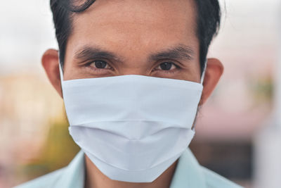 Close-up portrait of man wearing flu mask outdoors