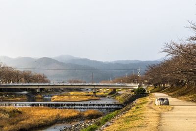 Road by bridge against sky