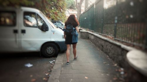 Blurred motion of person walking on footpath in city