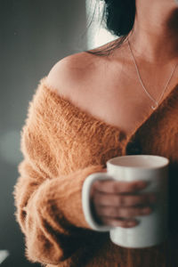 Midsection of woman holding coffee cup