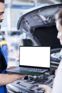 Midsection of businessman using laptop