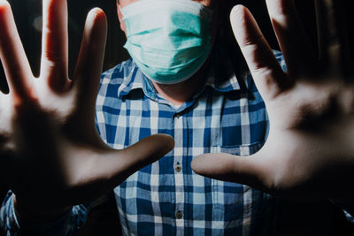 Portrait of man covering face with hands