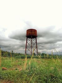 Low angle view of windmill on field against sky