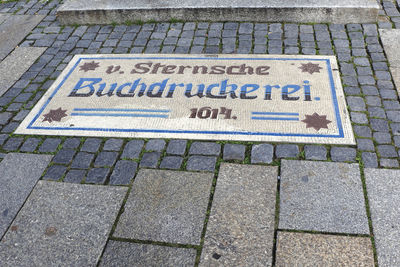 High angle view of text on paving stone