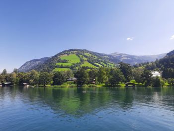 Scenic view of lake by mountains against clear sky