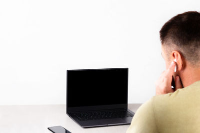 Man using mobile phone against white background