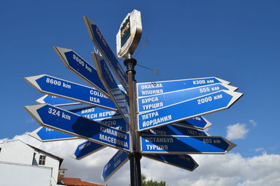 Low angle view of information sign against blue sky