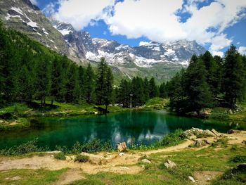 Scenic view of lake by mountains against sky