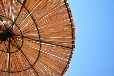 Low angle view of wood against clear blue sky