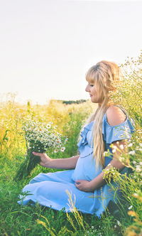 Young woman sitting on field