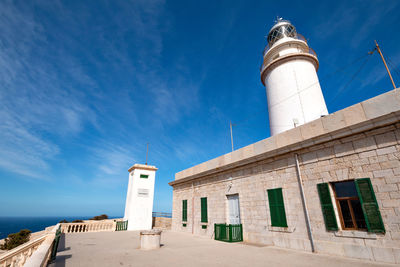 Low angle view of lighthouse against building