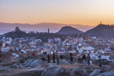 Town by mountains against sky during sunset