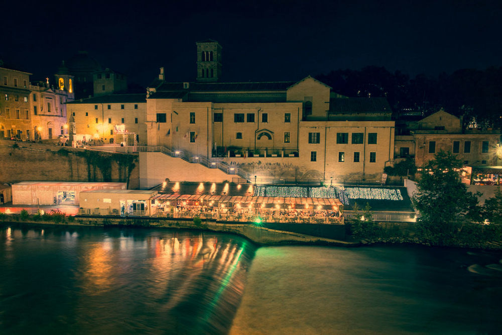 ILLUMINATED CITY BY RIVER AGAINST SKY