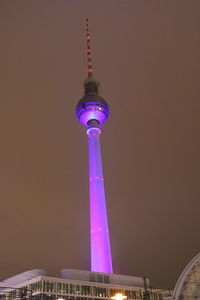 Low angle view of illuminated tower against sky at night