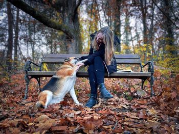Side view of young woman sitting on field