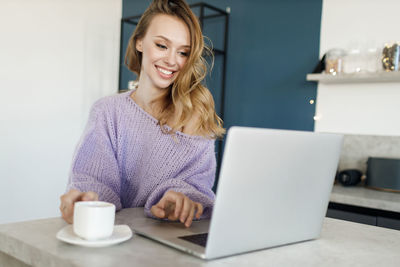 Young smiling businesswoman using laptop at office