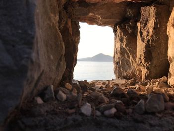 Rock formations at beach during sunset