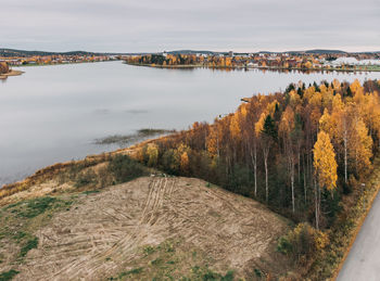 High angle view of lake amidst trees against sky