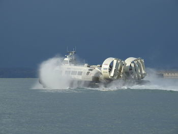 Boat sailing in sea against clear sky