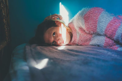 Portrait of woman lying on bed