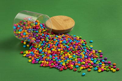 Colorful chocolate candy's, sugar coated chocolate gems candy on colorful background.