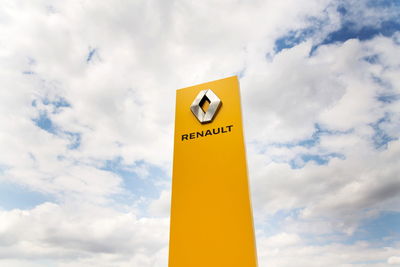 Low angle view of information sign against sky