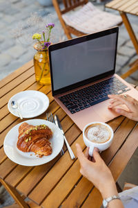 Midsection of woman using laptop on table