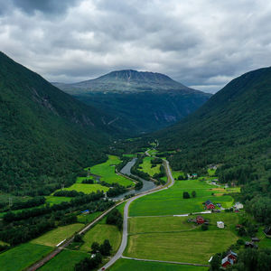 Scenic view of green landscape and mountains against sky