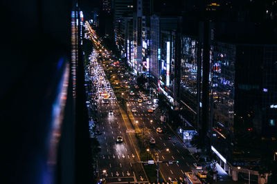 High angle view of road amidst illuminated buildings at night