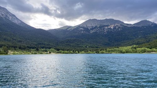 Scenic view of lake by mountains against sky