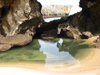 Rock formation in sea against sky