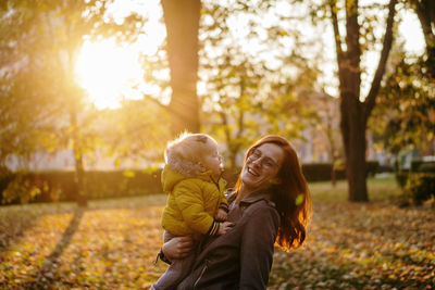 Baby wanna kiss mother in park