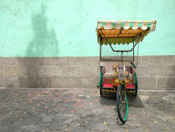 Bicycle on footpath against wall