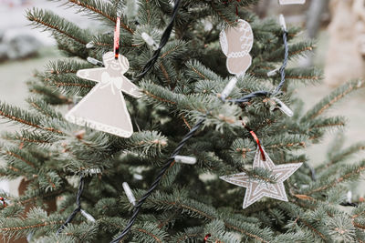 Handmade brown cardboard paper christmas decorations on christmas tree, outdoors. diy for children