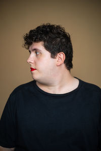 Portrait of young man looking away against white background