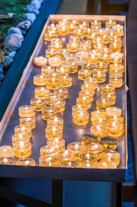 High angle view of lit tea light candles on table