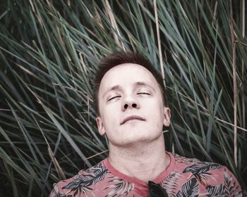 High angle view of man with eyes closed against plants