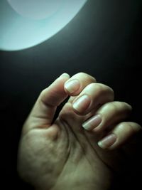 Close-up of man hand against black background