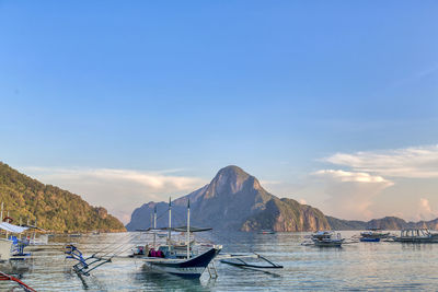 Boats moored in sea against sky