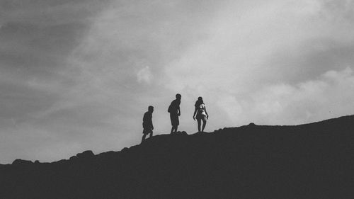 Low angle view of silhouette people against sky