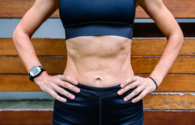 Midsection of woman standing against wall