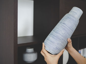 Midsection of person holding ice cream at home