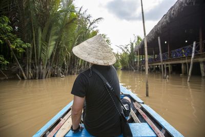 Rear view of woman standing in boat