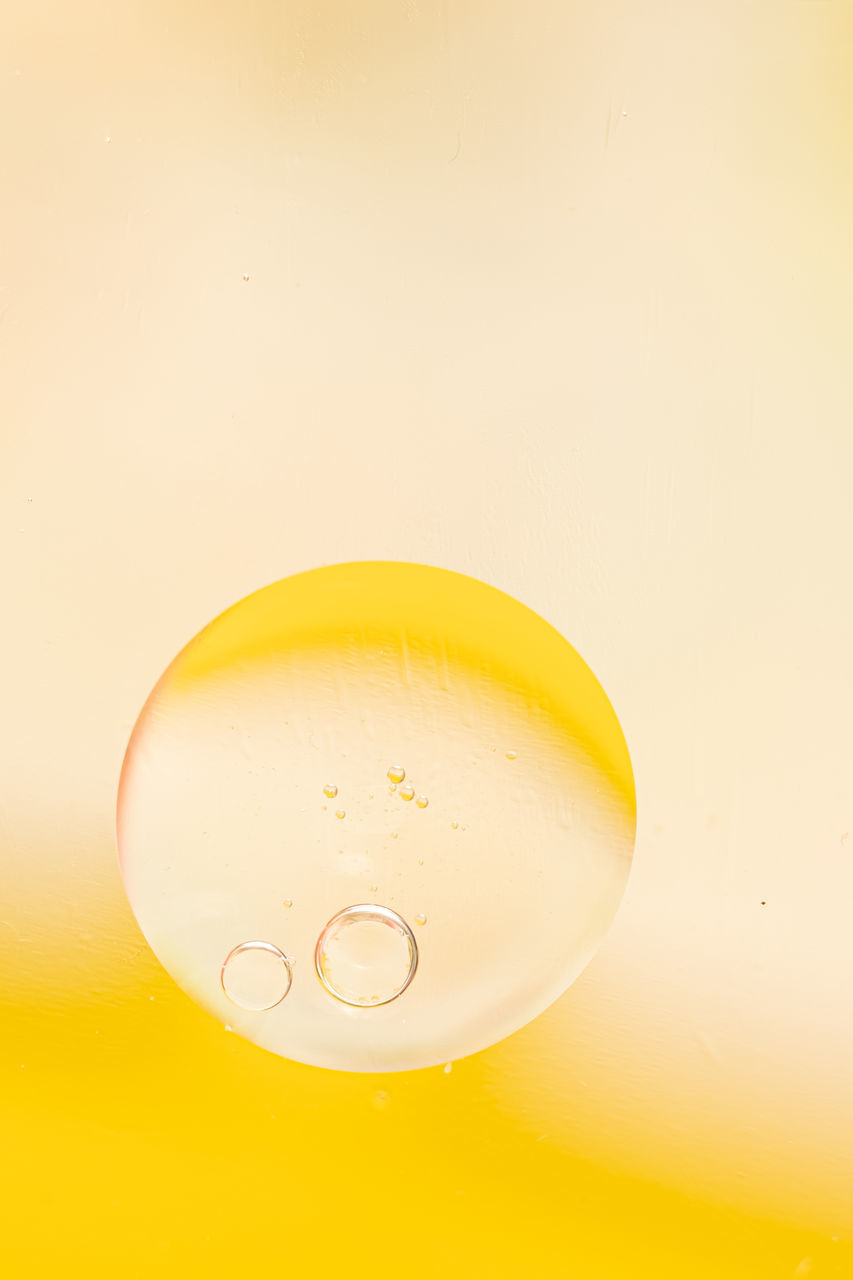 yellow, food and drink, refreshment, indoors, no people, drink, studio shot, colored background, water, bubble, close-up, drop, yellow background, freshness, geometric shape, circle, lighting, nature, drinking glass, copy space, household equipment