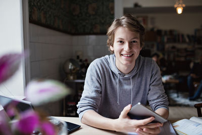 Portrait of smiling teenage boy studying at home